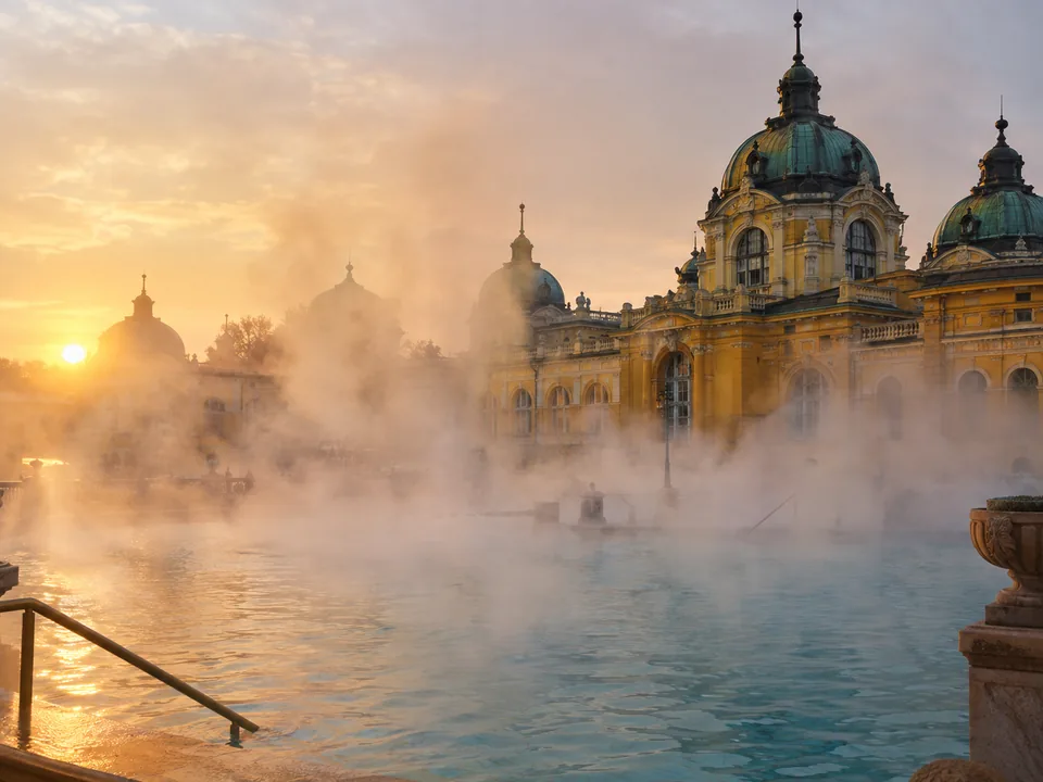 Vapore che sale dalla piscina termale esterna al mattino presto, con le ali gialle sullo sfondo